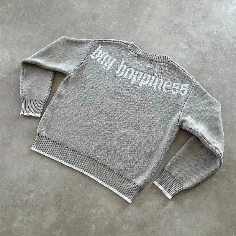 Grey loose-fitting jacquard knit pullover coat with long sleeves on a hanger.