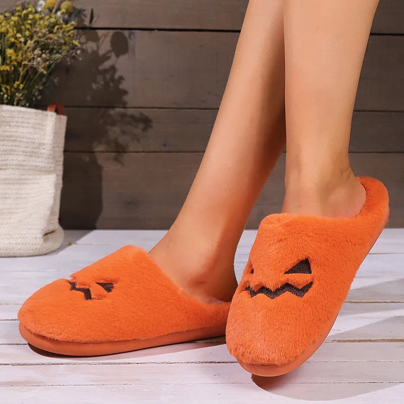 Orange women's pumpkin-themed plush slippers with a coral velvet upper and a flat non-slip sole.