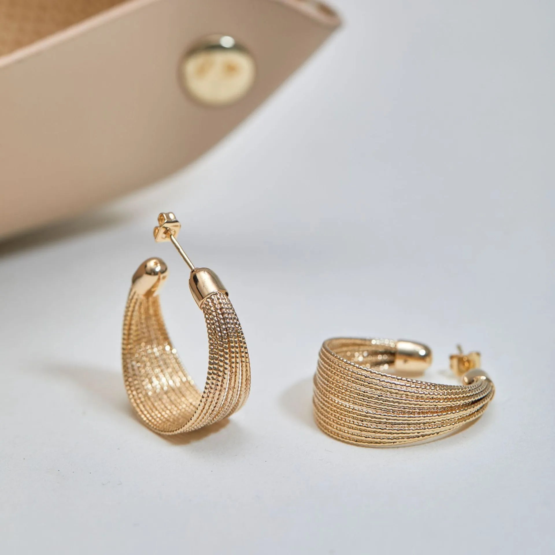 Geometric copper earrings with electroplated silver and gold finishes, including stud and clip-on options