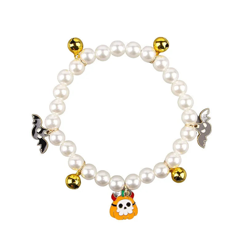 Close-up of a simulated pearl cat collar with a detailed Halloween pumpkin charm, showing the purple ghost design variant.