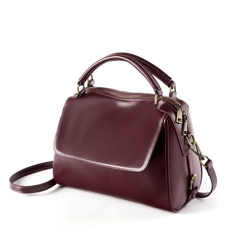 Women's soft cowhide leather crossbody tote bag in apricot colour, showing internal zip pockets and double shoulder strap.
