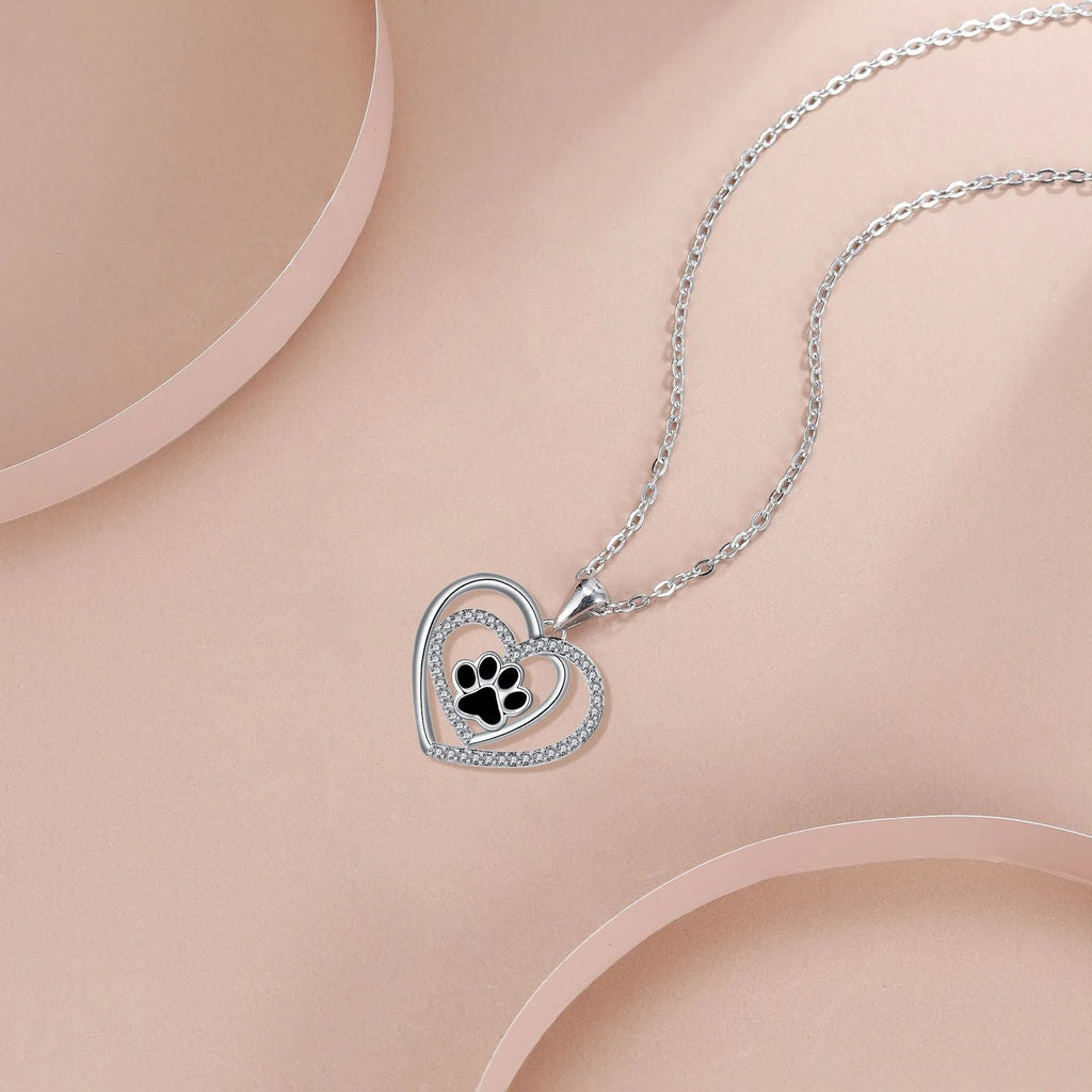 Women's necklace with a heart-shaped dog paw print copper pendant on a cross chain.