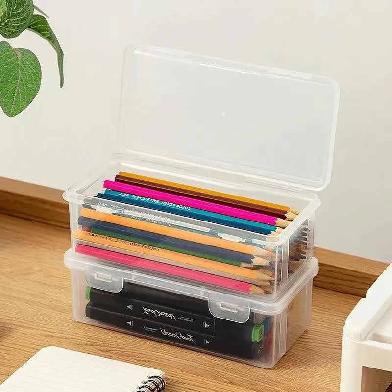 Large clear plastic stationery storage box filled with coloured pencils and wax crayons