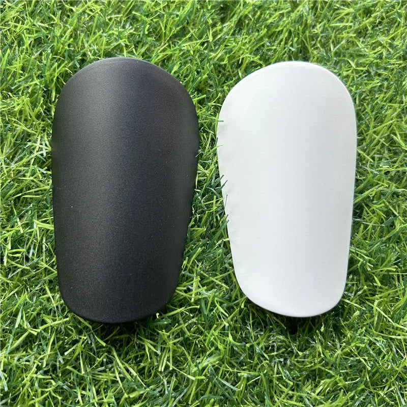 Extra small mini football shin guards in black and white colours measuring 8x5cm