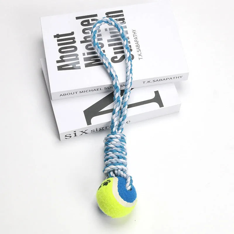 Braided red and white cotton rope dog tug toy for large breeds on a wooden floor.