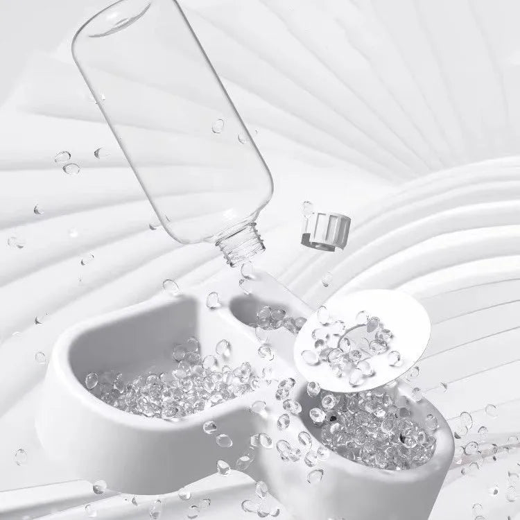 White automatic pet water fountain with stainless steel top on a floor.