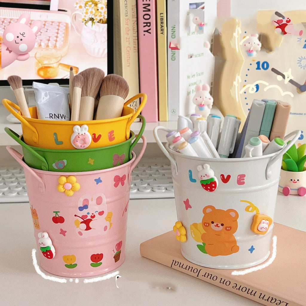 Round metal Creative Iron Art pen holder shown in pink, green, red, white, and yellow colour options on a desk.