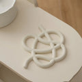 Ceramic heat proof mat with irregular shape on dining table, bright black solid colour