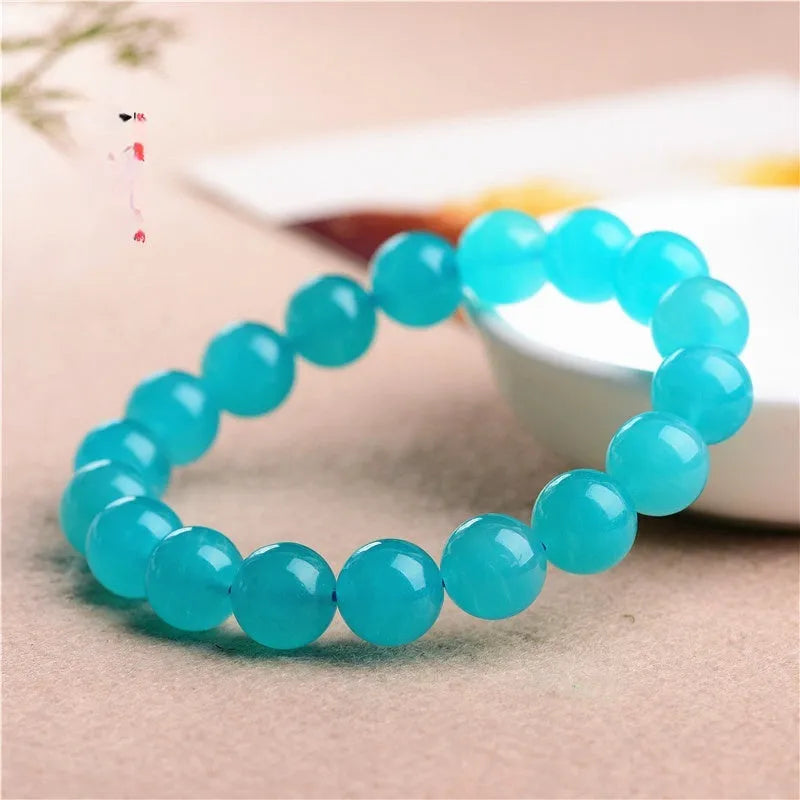 Polished natural Amazonite scattered beads in blue-green ice colours on a white background, showing different sizes from 6mm to 13mm.
