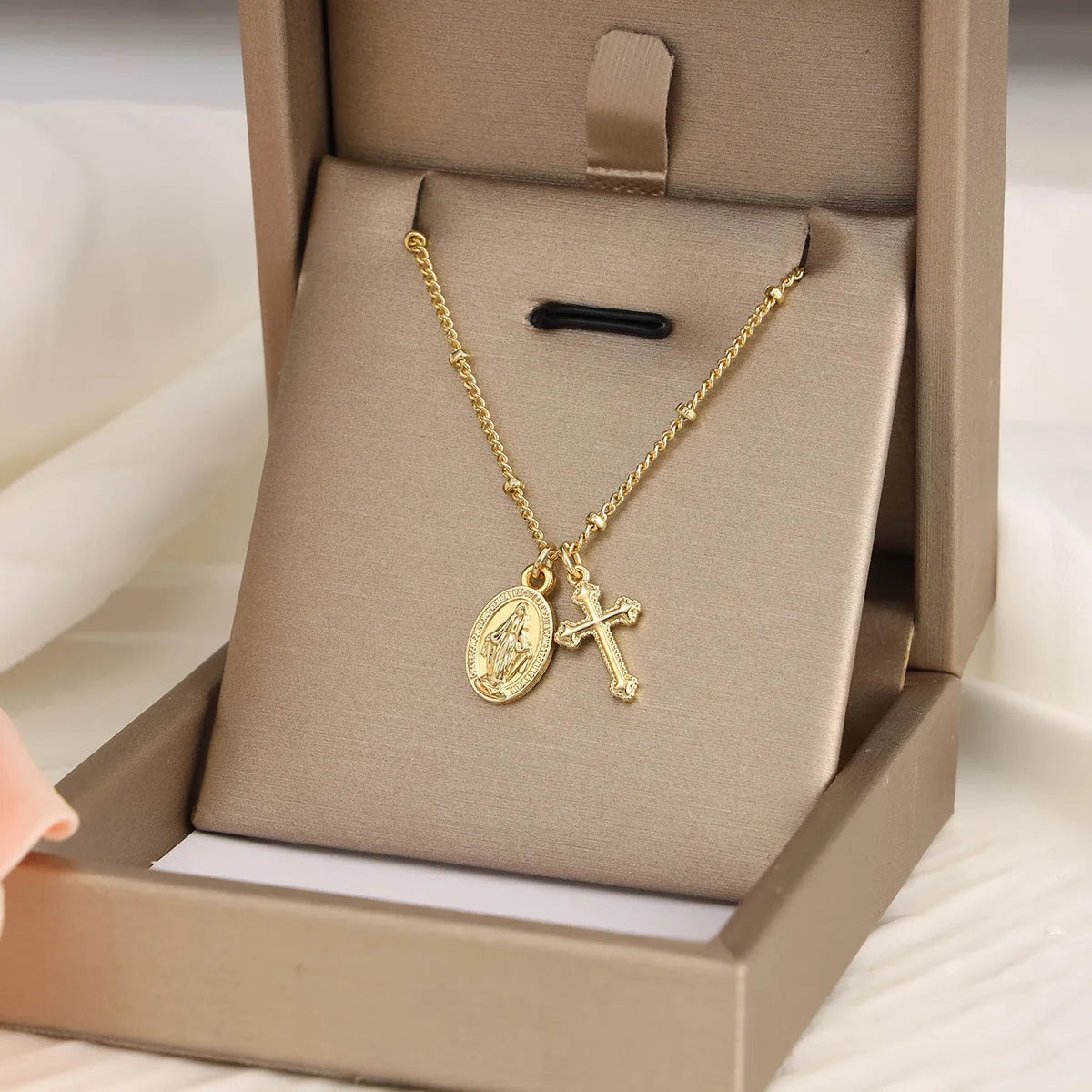 Gold Virgin Mary and cross geometric pendant necklace on a simple chain.