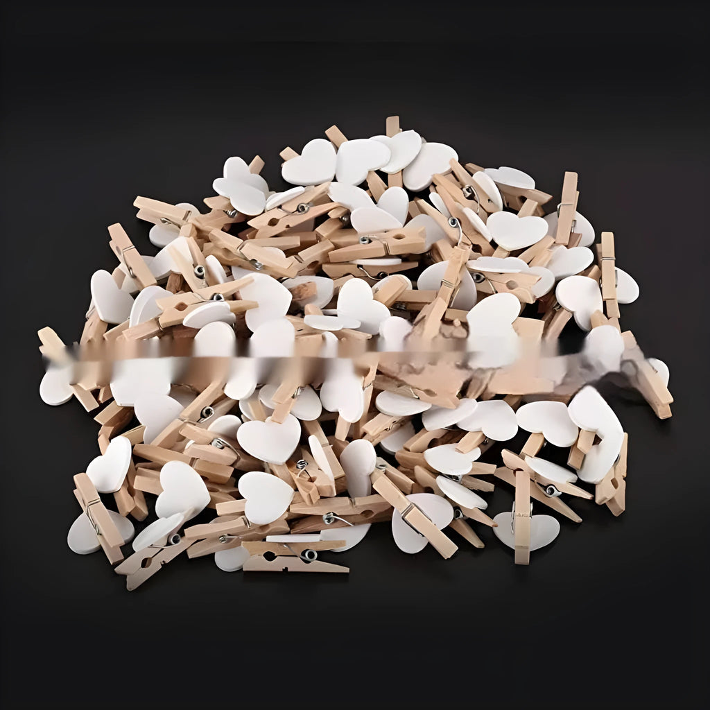 Five small solid wood heart-shaped clips in different colours showing handmade craft details