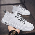 Men's white casual flat shoes with round toe and low heel on a plain background.