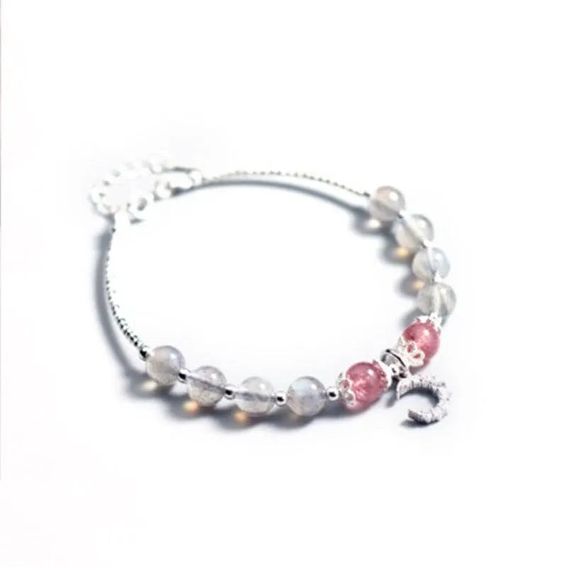 Natural moonstone bracelet with silver crescent moon charm on an adjustable chain.