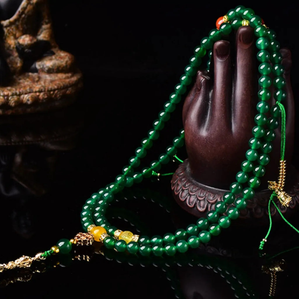 Natural green agate multi-strand bracelet with sliding knot closure on a wrist.