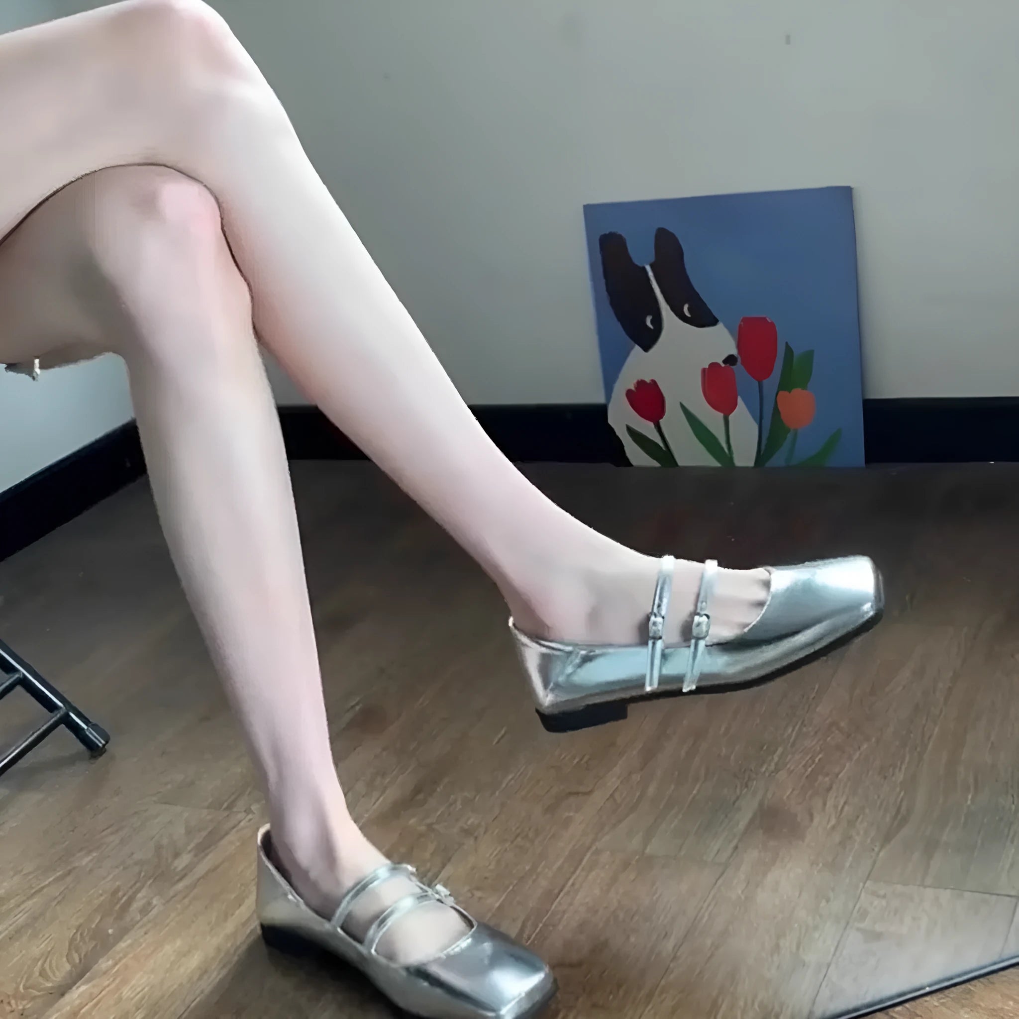 Women's silver sheepskin leather ballet flats with a cross buckle strap and round toe, shown on a plain background.