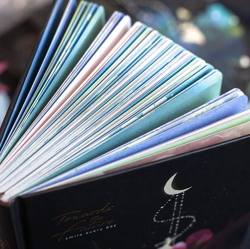 A5 spiral-bound notebook with a luminous holographic cover showing colour illustrations on the open pages.