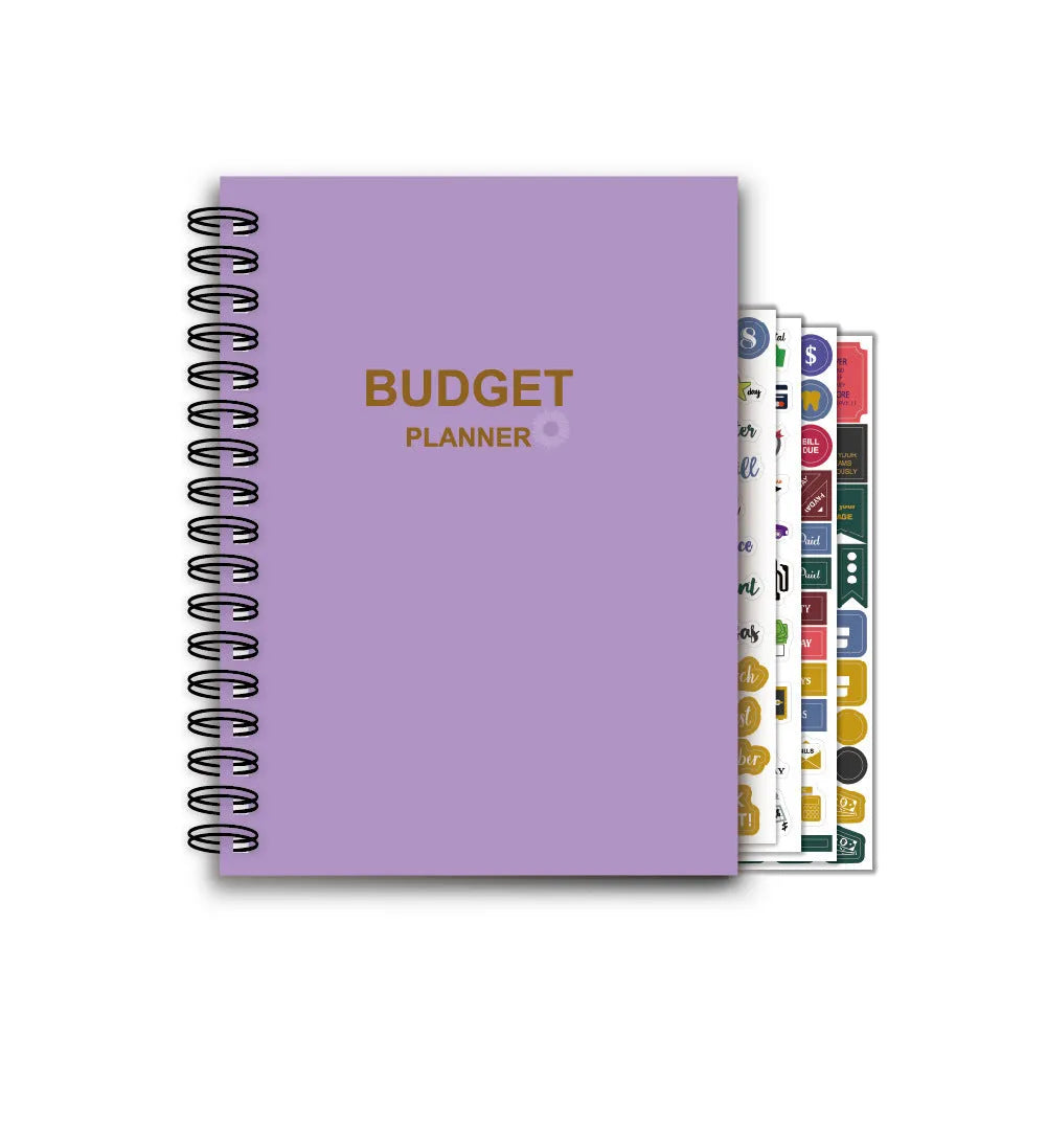 Purple coil-bound budget book open showing monthly financial planning layout with stickers and paper clips