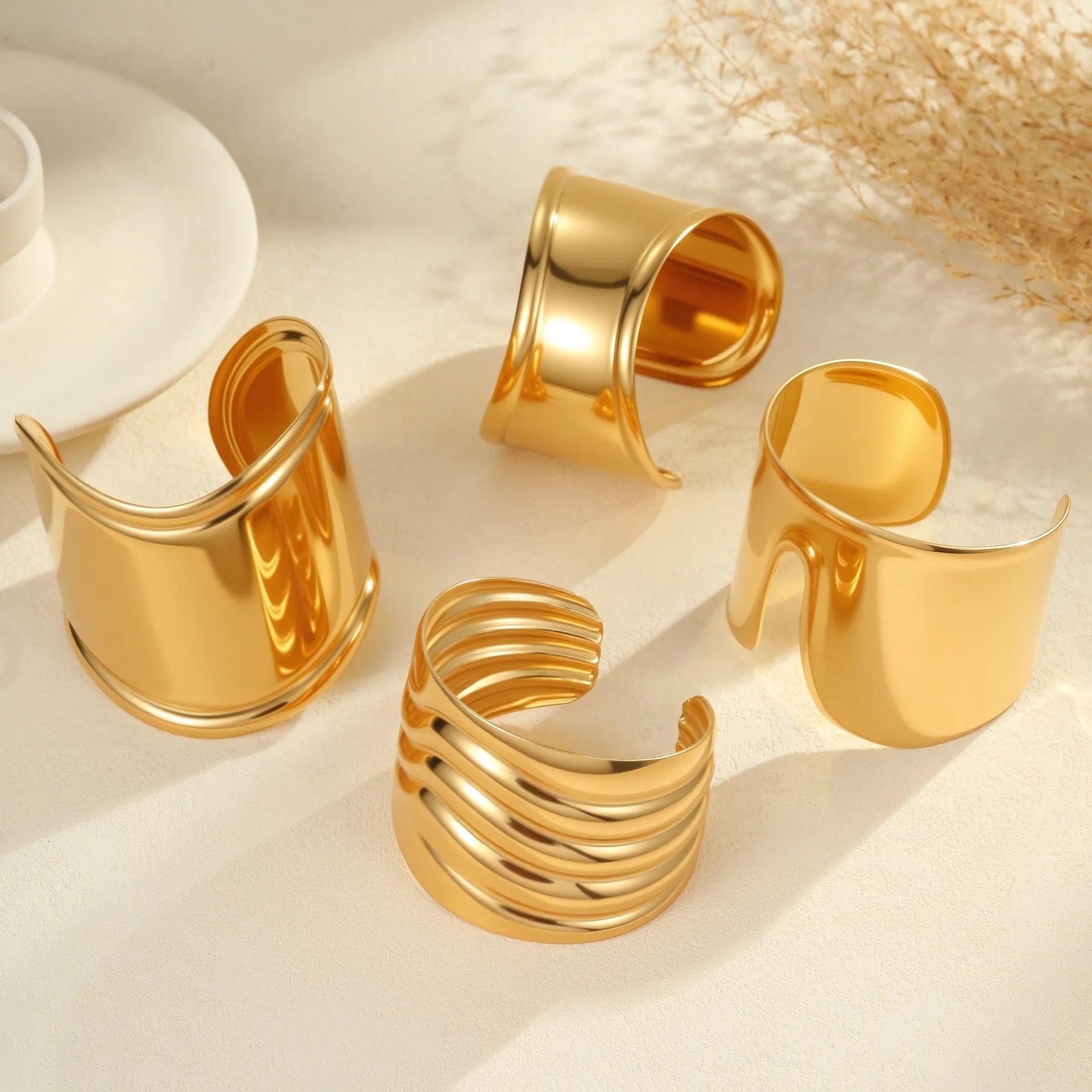 Women's exaggerated wide stainless steel bracelet with geometric wave design and niche opening in gold finish