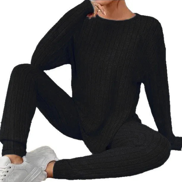 Women's black two-piece lounge set with a sunken stripe pattern on the top and matching trousers.