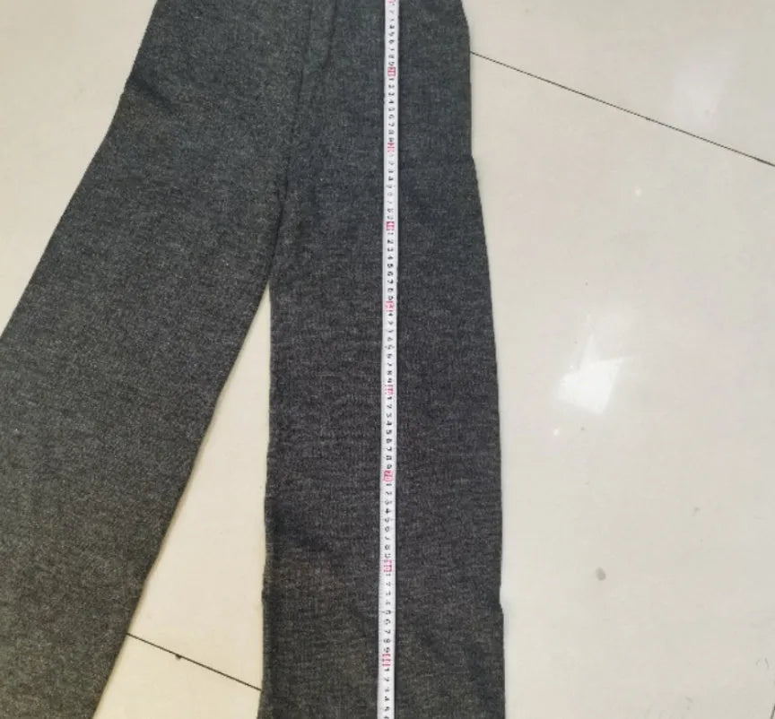 Women's acrylic suit set showing side-slit sweater top with matching trousers in solid colour