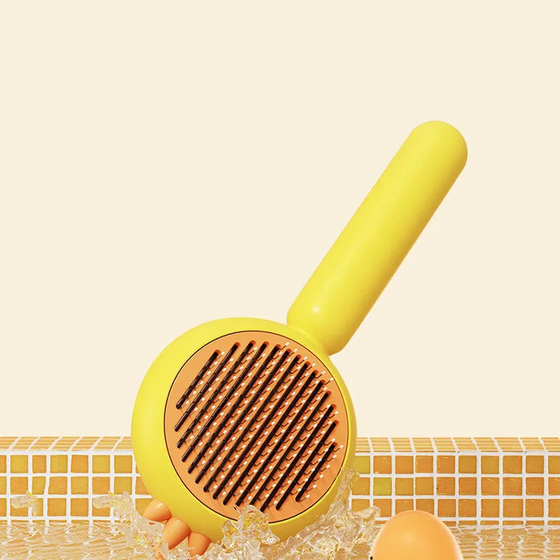 Purple pet grooming brush with stainless steel bristles and a one-button self-cleaning mechanism on a white background.