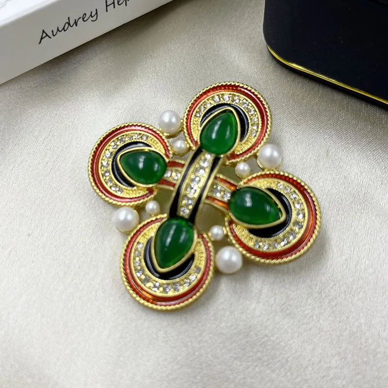 Close-up of a medieval-style baroque cross brooch with crystal decoration on a metal base.