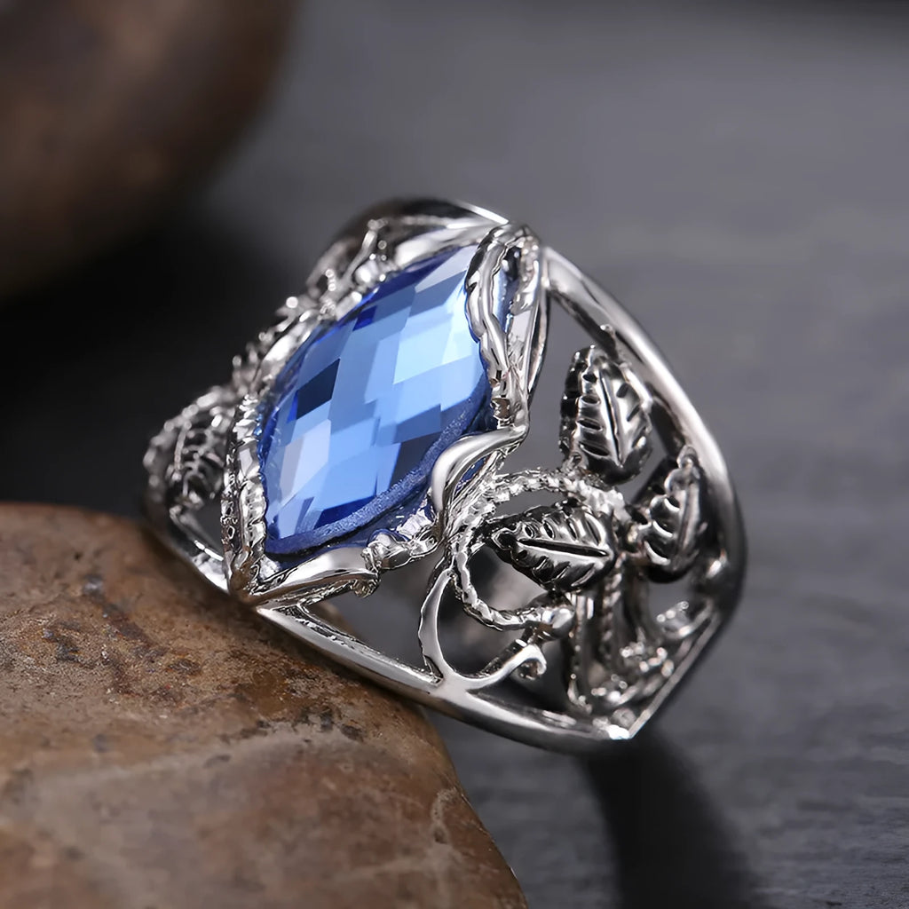 Blue crystal inlay on a geometric horse eye-shaped alloy ring for women.