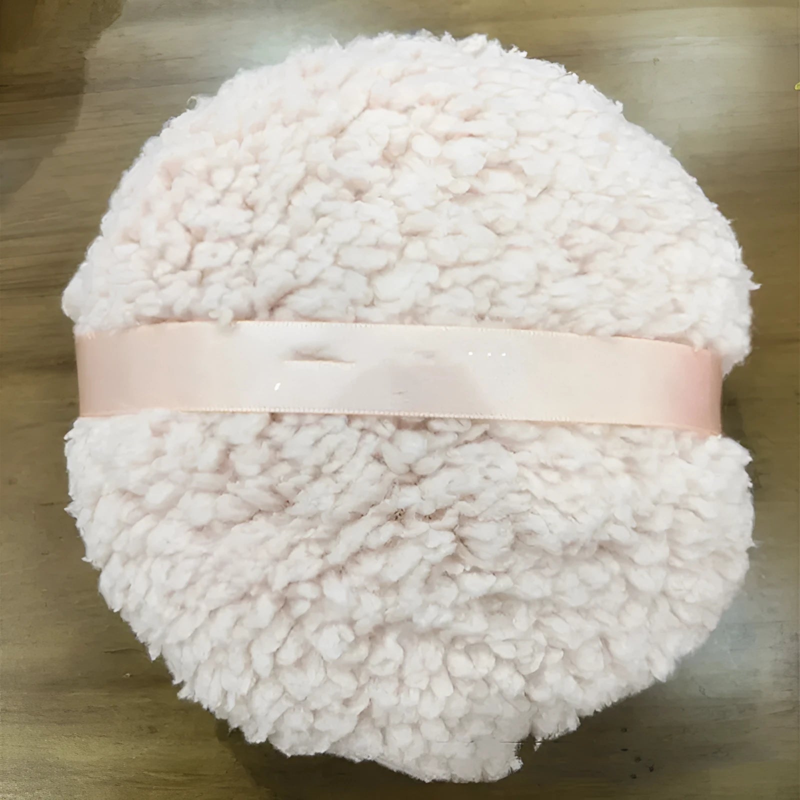Oversized rectangular plush powder puff for makeup application in pink, white, or skin colour.