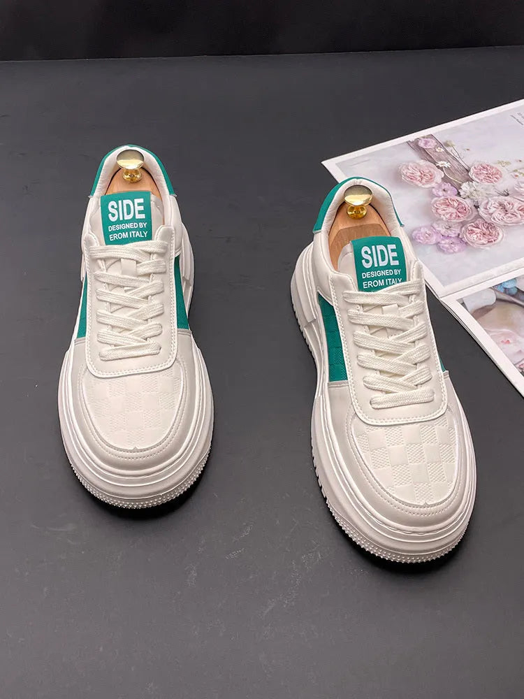 White and green sports casual shoes with cloth upper and rubber foam sole on a plain background.
