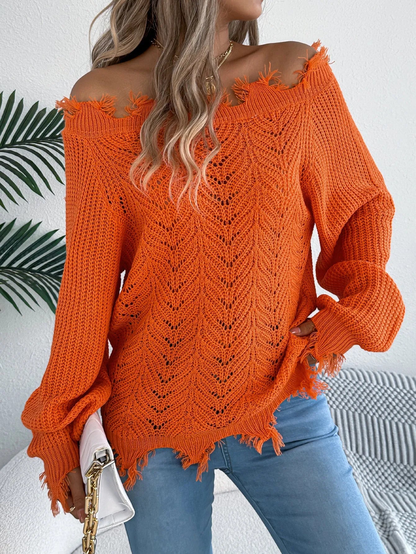 White hollow-out cut-off shoulder pullover sweater with long sleeves on hanger