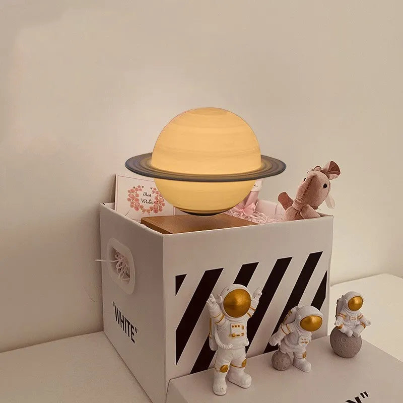 Maglev floating moon and earth night light with LED glow and small astronaut figurines on a table.