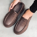 Men's black slip-on platform shoes with round toe and mid-top design on a white background.