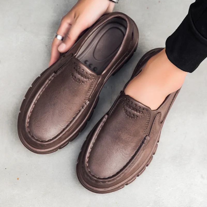 Men's black slip-on platform shoes with round toe and mid-top design on a white background.