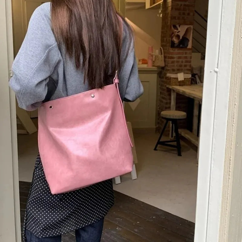 Corduroy one-shoulder commuter bag in pink colour showing textured fabric and structured design