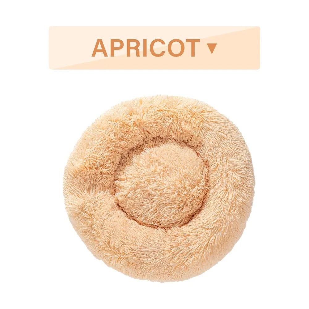 Fluffy donut-shaped dog bed in long plush fabric, shown in a light grey colour with a raised edge.