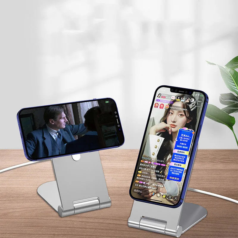 Silver vertical adjustable magnetic phone bracket for iPhone 12 on a table.