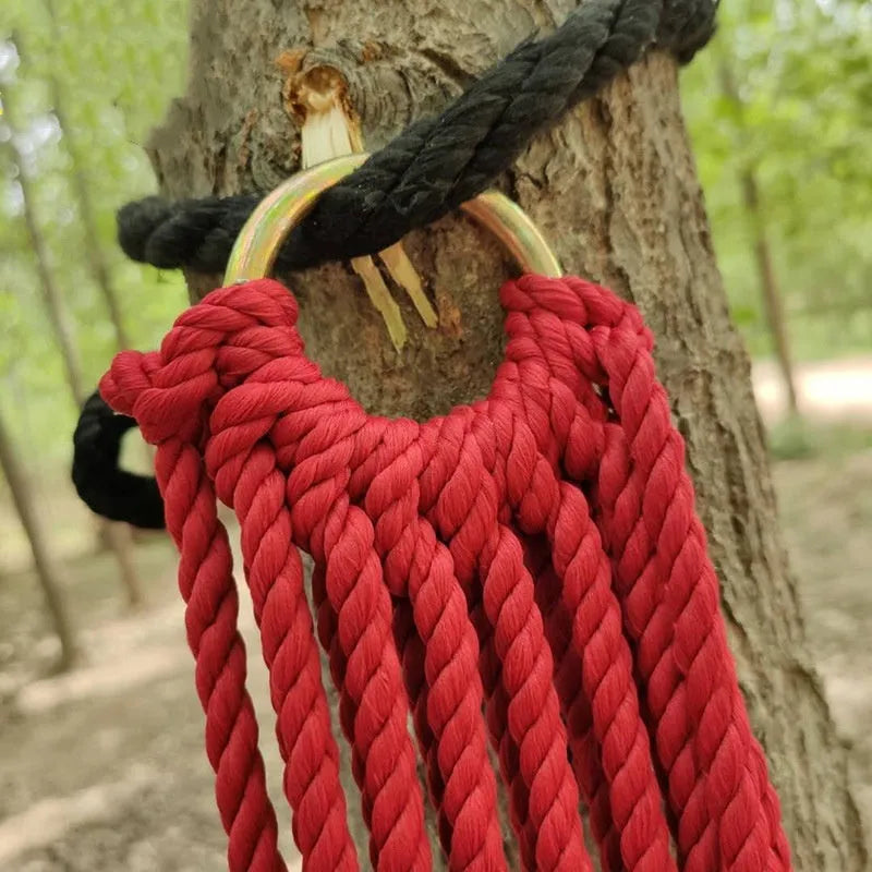 Nylon rope mesh hammock suspended between trees showing mesh pattern and included tying equipment