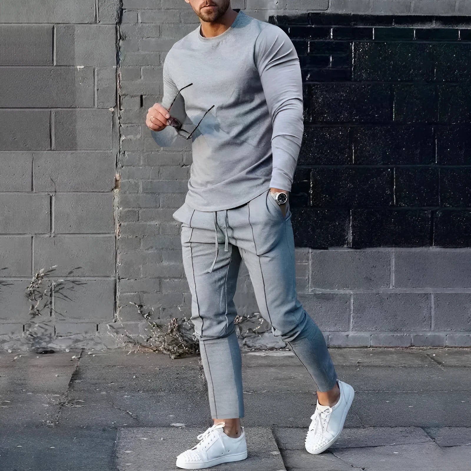 Man wearing a light grey round-neck long-sleeve t-shirt and matching trousers from a two-piece polyester suit set.