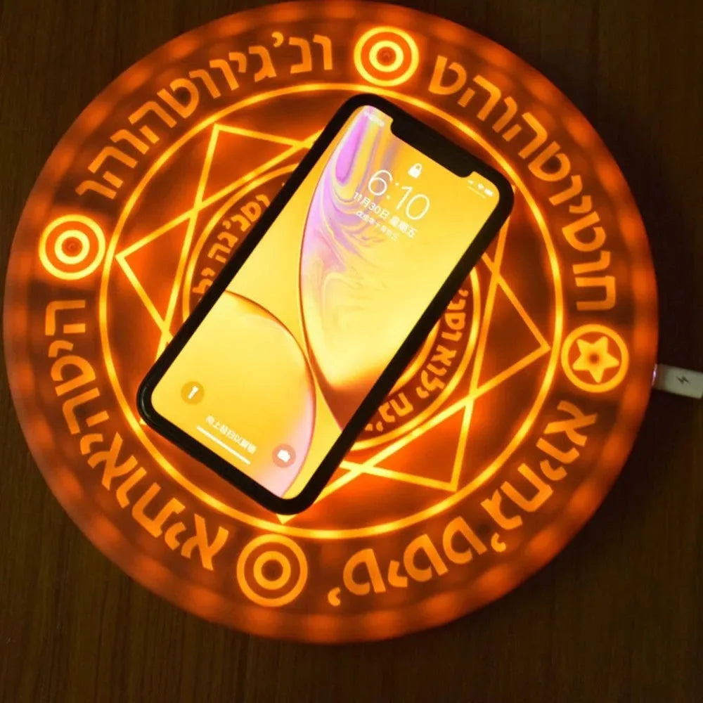 Black 10W fast wireless phone charger with glowing magic array pattern on a desk.