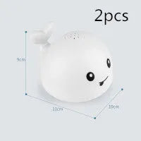 White and blue whale-shaped bath toy with water spray and LED lights floating in water