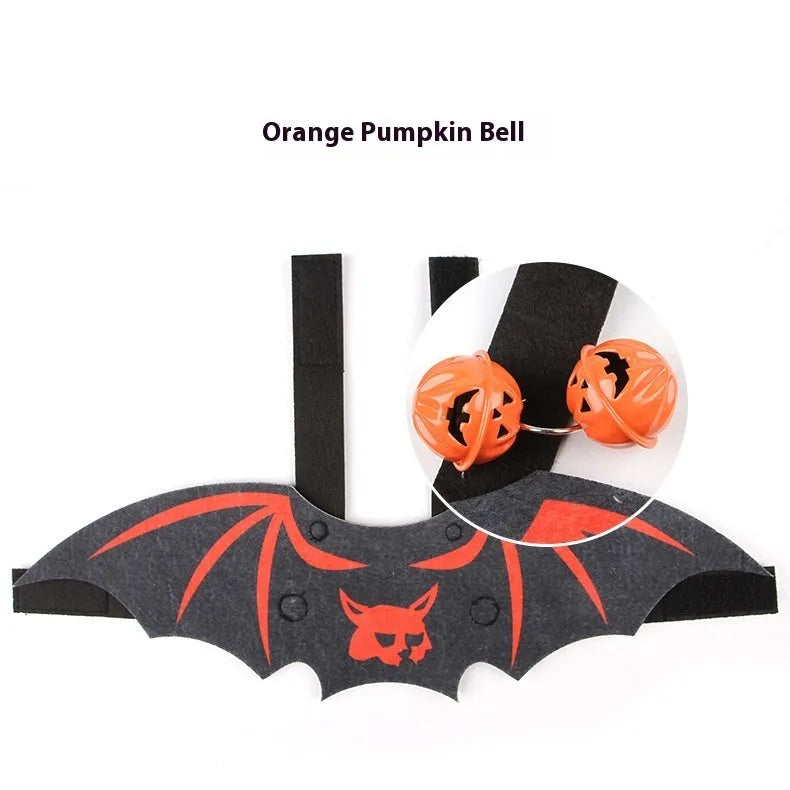 Black cat wearing an orange felt batwing Halloween costume with bell attachment.
