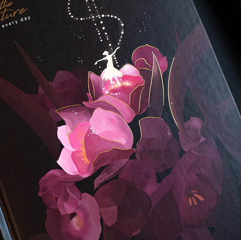 A5 spiral-bound notebook with a luminous holographic cover showing colour illustrations on the open pages.