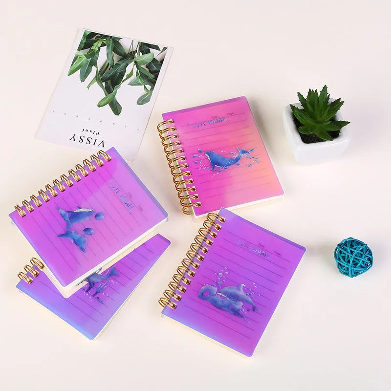 Set of four A7 spiral notebooks with different coloured PP plastic covers, showing spiral binding and open page.