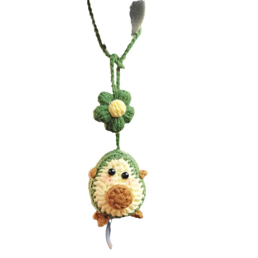 Handmade crocheted avocado flower car pendant in wool with rainbow colours hanging in vehicle