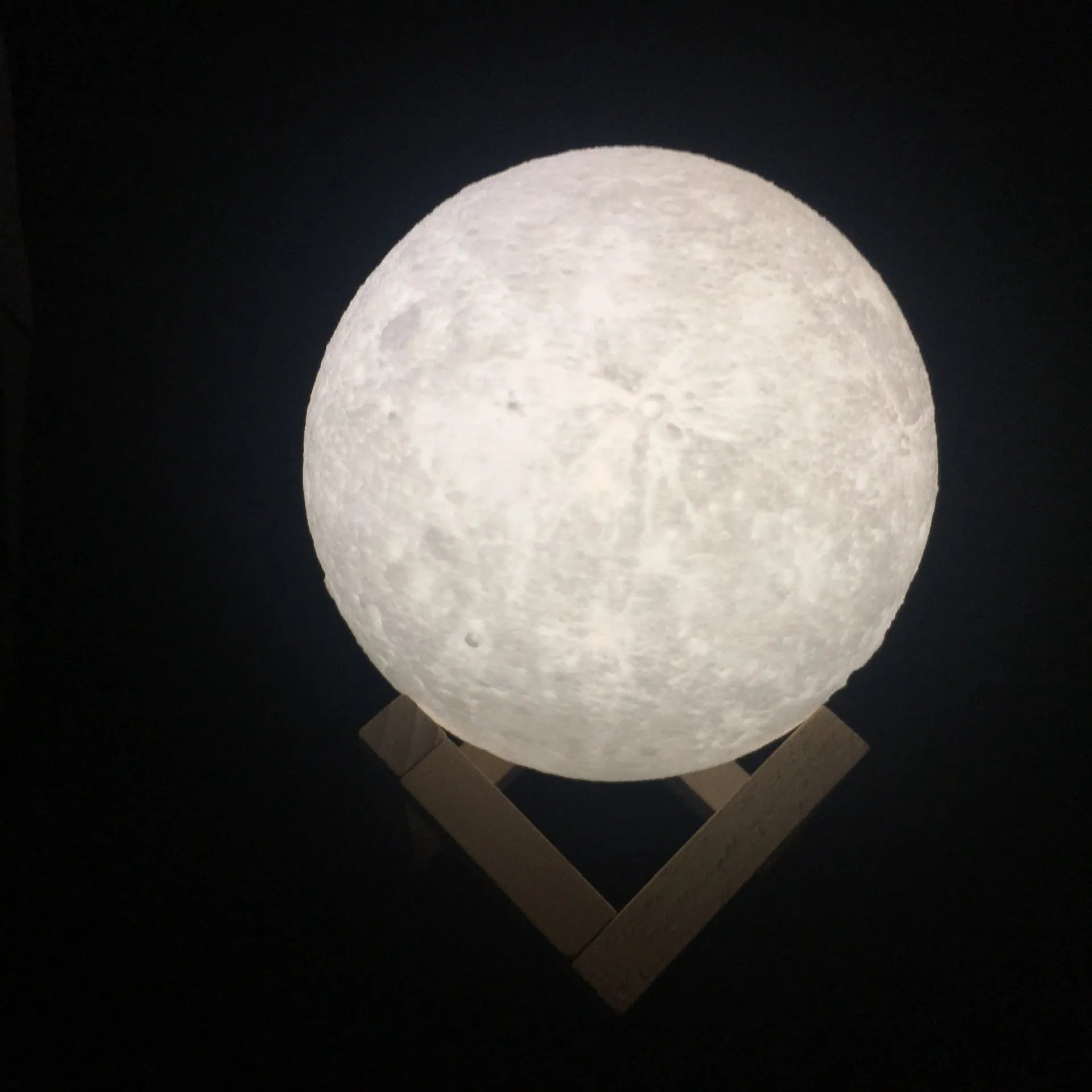 3D printed spherical moon lamp on a wooden stand with touch ring control