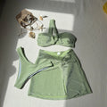 Women's light green one-shoulder tube top swimsuit with matching pants and skirt.