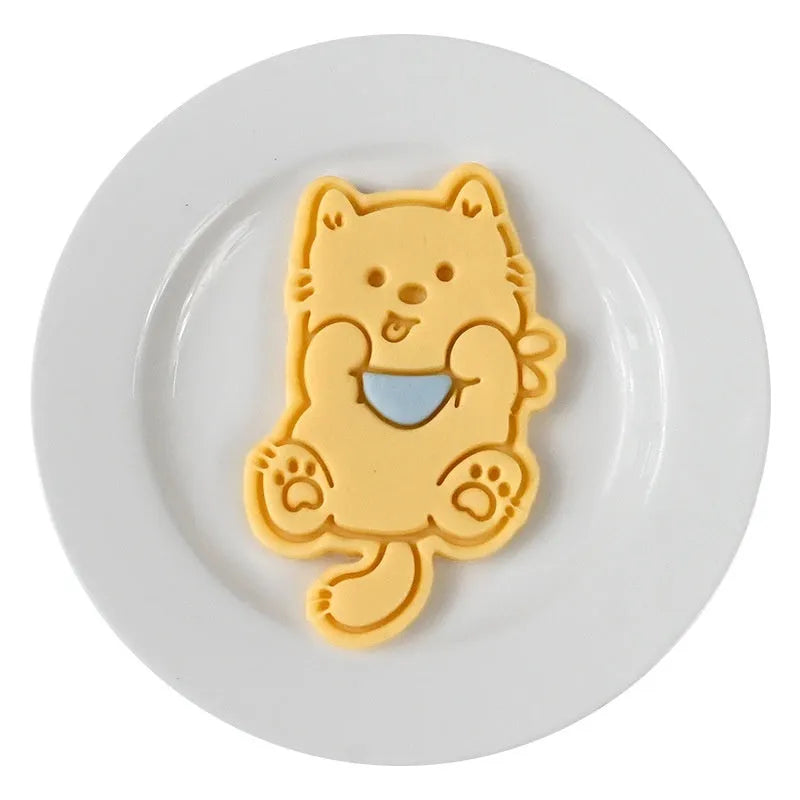 Three dimensional plastic biscuit mold showing puppy head and birthday hat designs