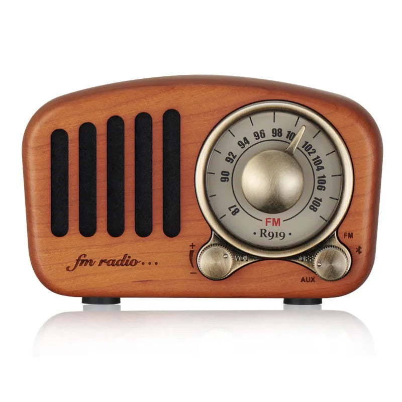Compact retro wooden wireless Bluetooth speaker in cherry wood finish on a wooden table