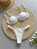 Women's black underwire bikini top and briefs set on a mannequin, showing sleeveless design.