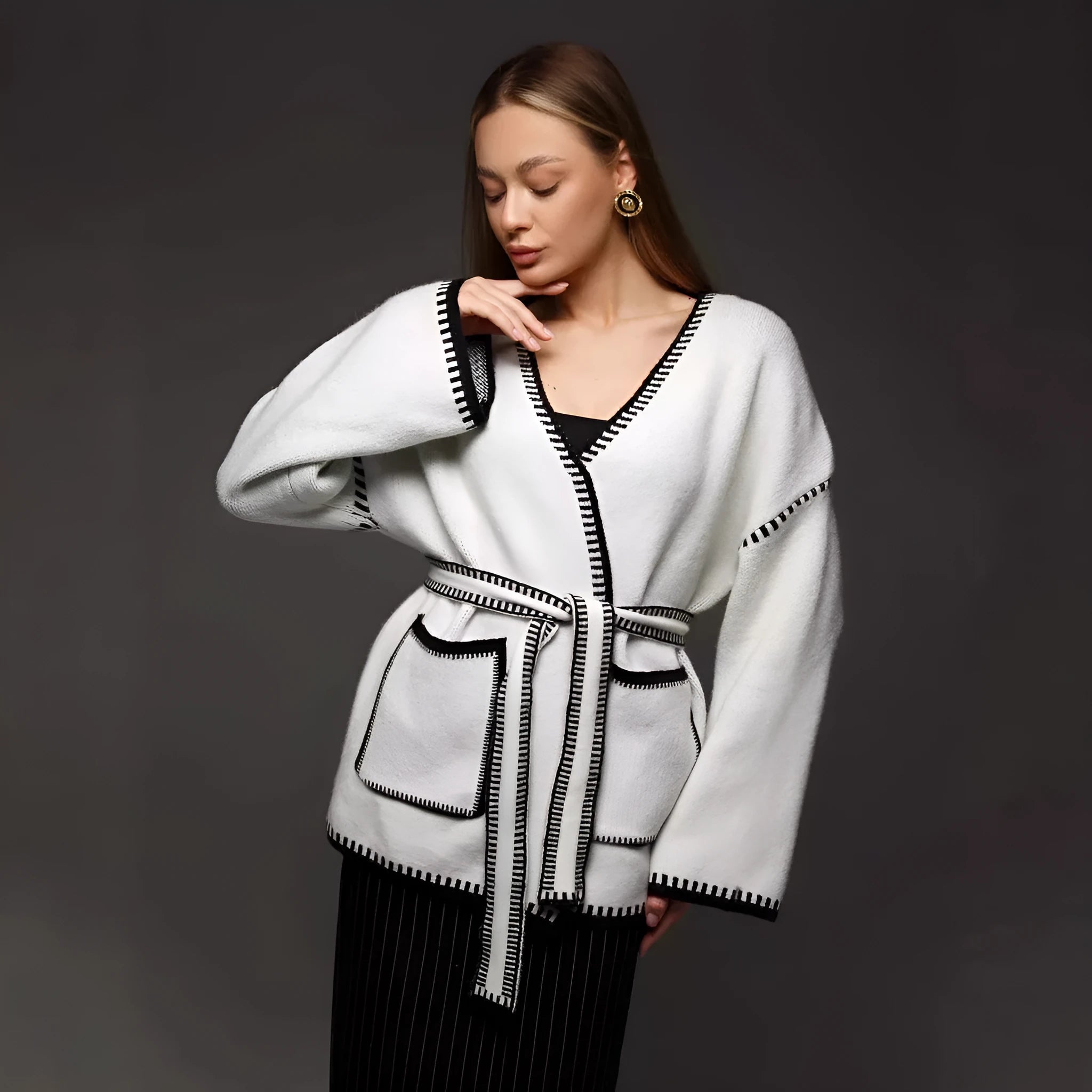 Loose fit knitted cardigan sweater coat in camel colour, showing long sleeves and mid-length hem.